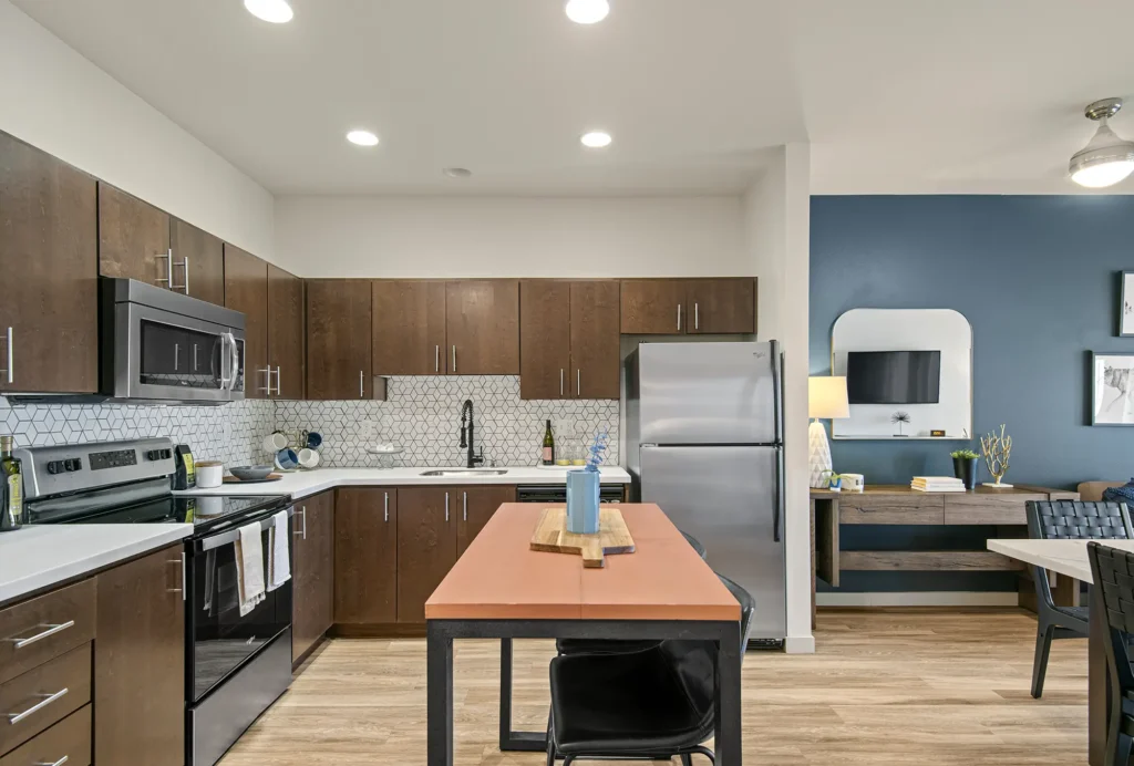 Kitchen with stainless steel appliances and brown cabinets at VUE25 apartments in Tacoma
